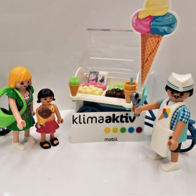 Playmobil Figuren stehen bei einem Eiswagen mit Eisverkäufer