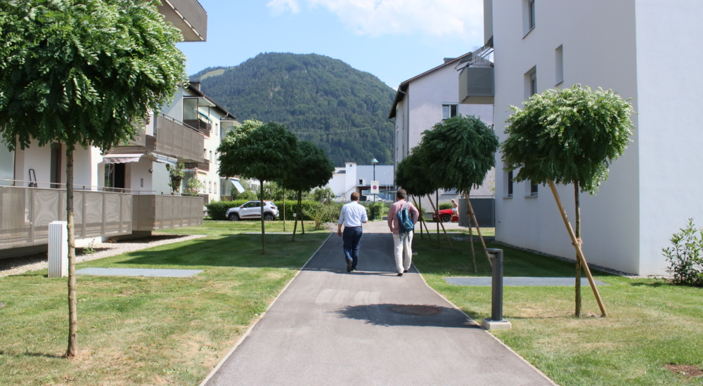 Weg durch Wohnhäuser mit Bäumen in der Gemeinde Wörgl