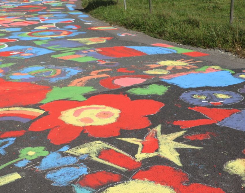 bunt bemalte Straße in Nahaufnahme, am Wegrand Gras