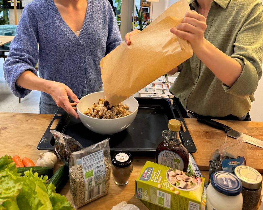 Zwei Frauen kippen Brotwürfel in eine Schüssel