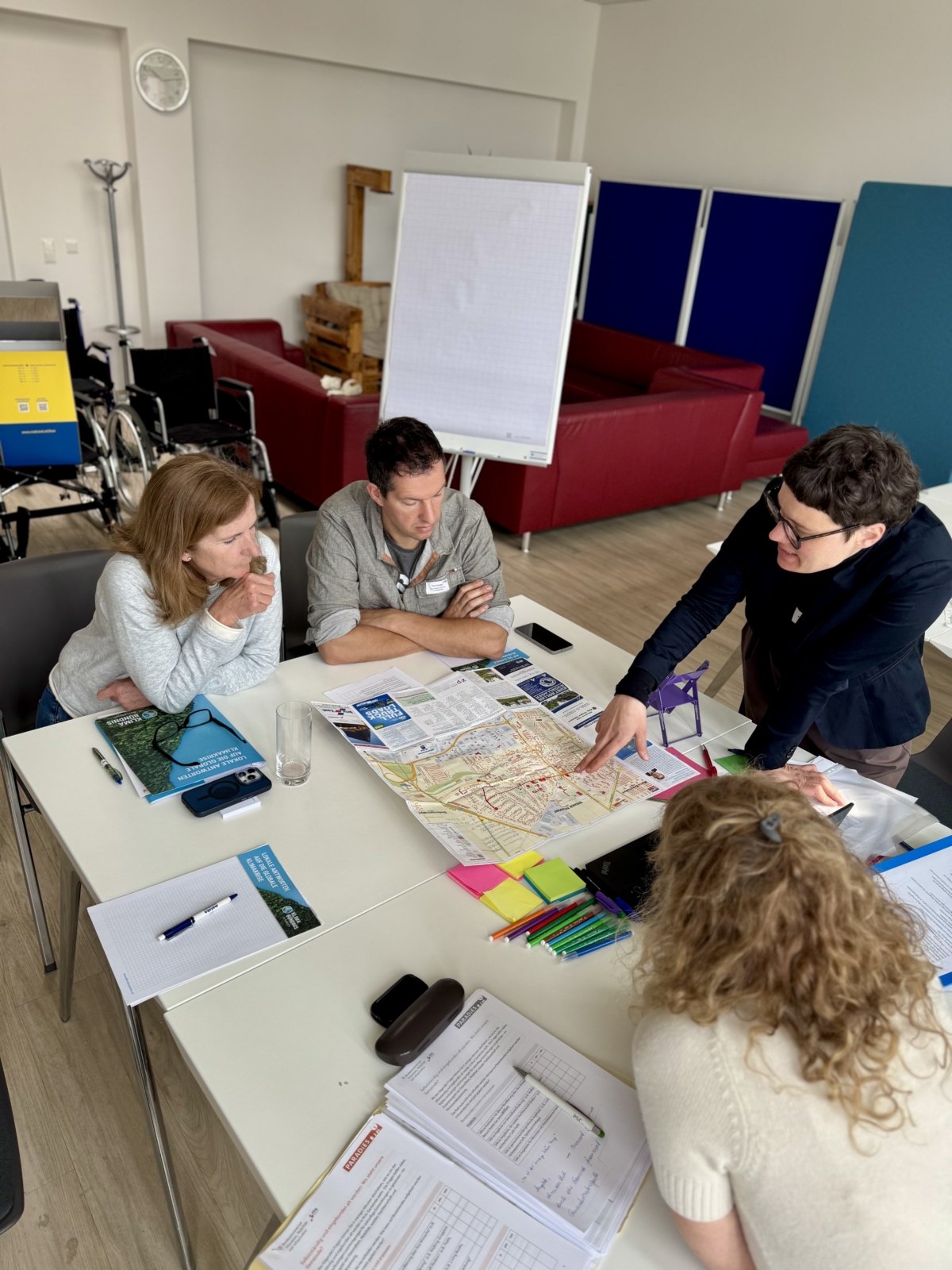 Vier Menschen diskutieren über einen Flyer